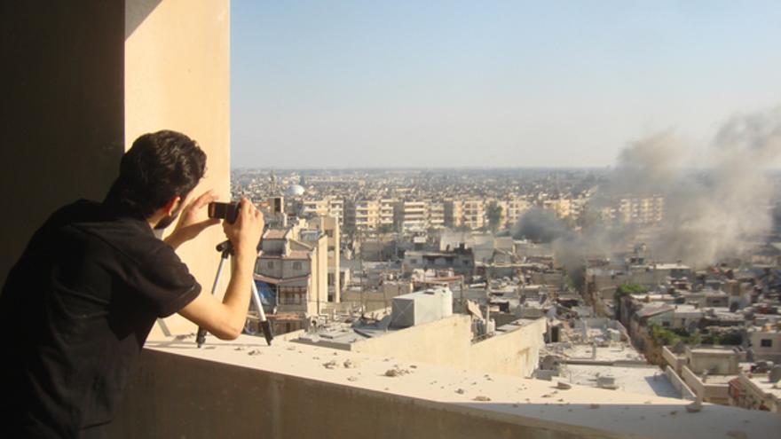  Un activista hace fotos del humo procedente de Juret al-Shayah, en Homs, julio 2012 © REUTERS/Shaam News Network/Handout