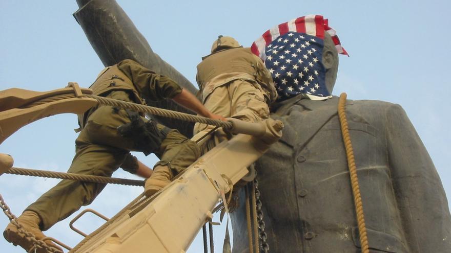 Tropas estadounidenses colocando la bandera de EEUU en una estatua de Sadam Hussein (Bagdad, 9 de abril 2003)