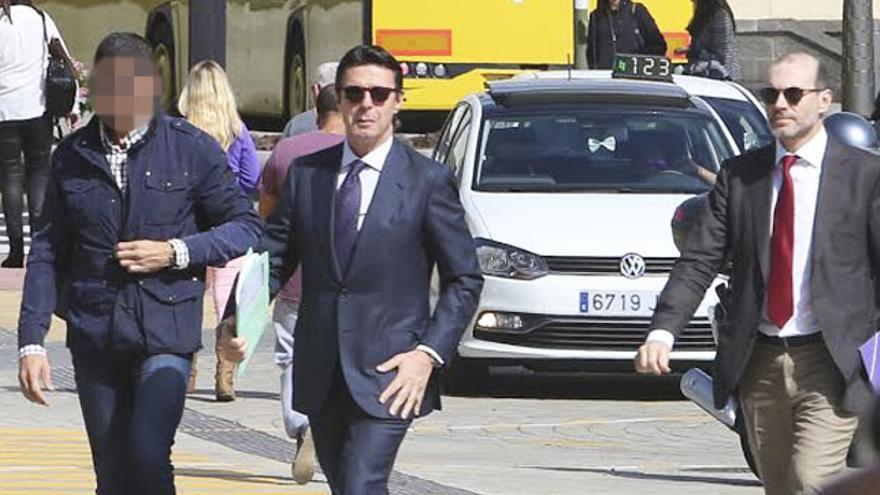 José Manuel Soria, junto a su abogado, Nicolás González-Cuéllar, y un escolta policial, en la Ciudad de la Justicia de Las Palmas de Gran Canaria. (ALEJANDRO RAMOS)