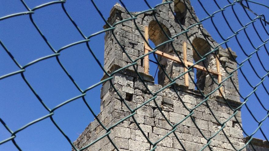 Muro derrumbado en la iglesia románica, que se encuentra al lado de la valla instalada por el empresario que ha convertido el pueblo en un coto de caza