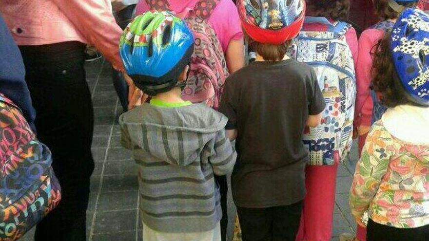Niños acudiendo al Colegio Cervantes con casco. Foto vía @vicentjuanmtnez
