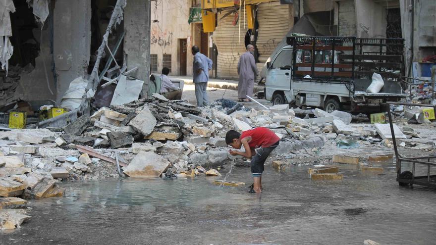 Barrio de Kalaseh en Alepo, una zona atacada por misiles en agosto de 2014. La foto fue tomada el 1 de septiembre y muestra a un niño bebiendo agua del lugar donde ha caído un misil. Amnesty International (Photo: Mujahid Abu al-Joud) .