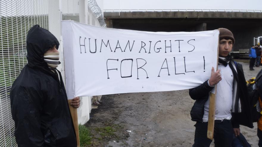 "Derechos humanos para todos", reza la pancarta que portan dos refugiados en el campamento de Calais / Eduardo Granados 