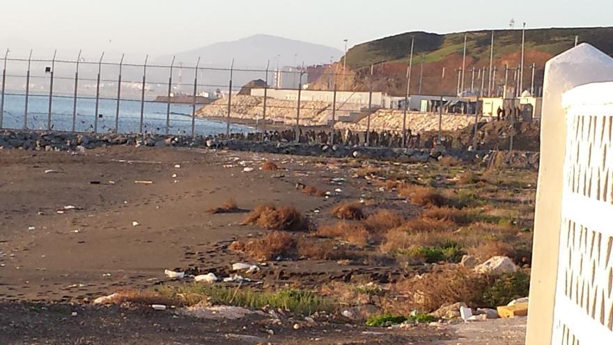 Imagen realizada desde Ceuta, con un grupo de personas de origen subsahariano al fondo.