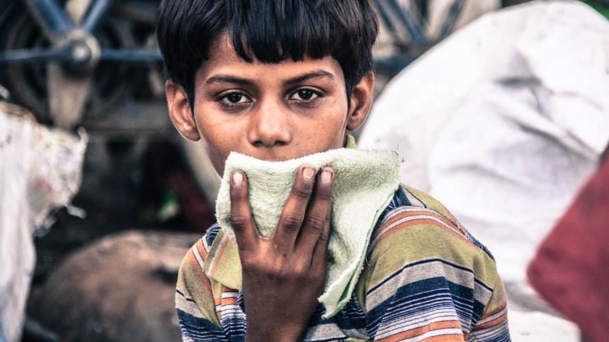 Un niño aspira pegamento en el slum de la estación de tren de Varanasi (Foto: Juan Luis Sánchez)