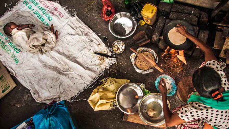 Una mujer prepara comida junto a las vías del tren en un slum de Varanasi, India. Octubre de 203 (Foto: Juan Luis Sánchez)