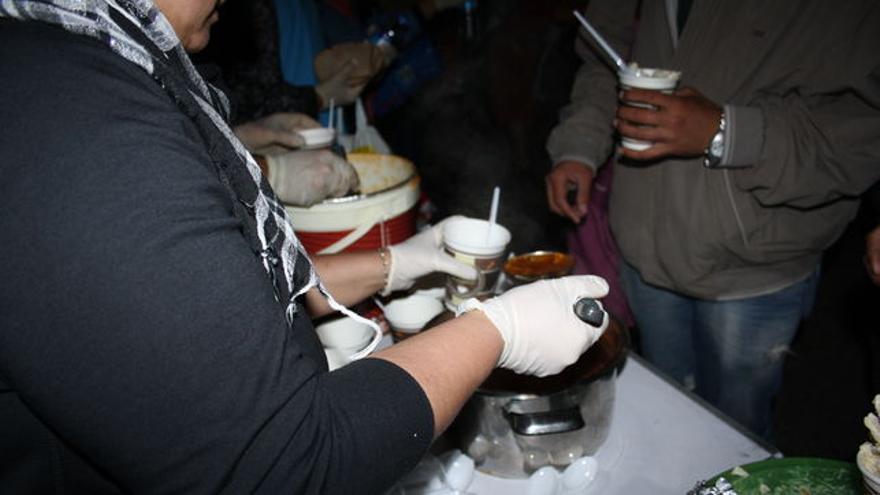 Voluntarios reparten la única comida de la noche para algunos refugiados financiada con donaciones. / FOTO: C. Negrete
