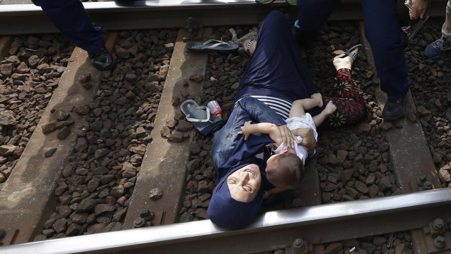 Una mujer se tira a las vías del tren para protestar contra el intento de las autoridades húngaras de trasladar a cientos de refugiados a un centro de acogida/ APP - David Josek