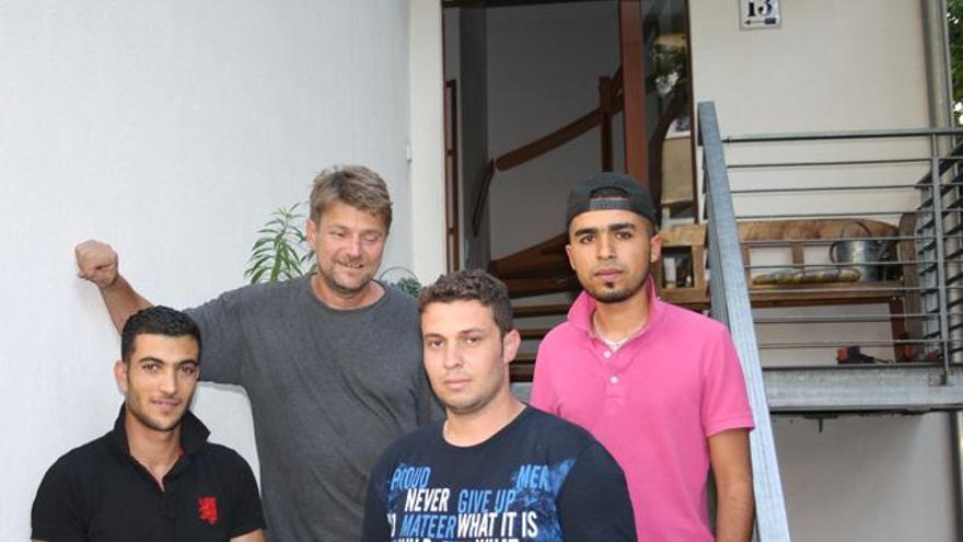 El periodista Bern Pickert con tres de los refugiados que ha acogido en su casa este fin de semana para que no tuvieran que dormir en la calle. / FOTO: C. Negrete
