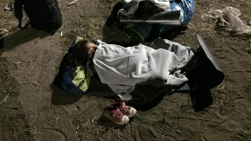 Un niñor refugiado duerme a la intemperie a las puertas de un campo de refugiados cerca de la frontera de Hungría con Serbia | Olga Rodríguez