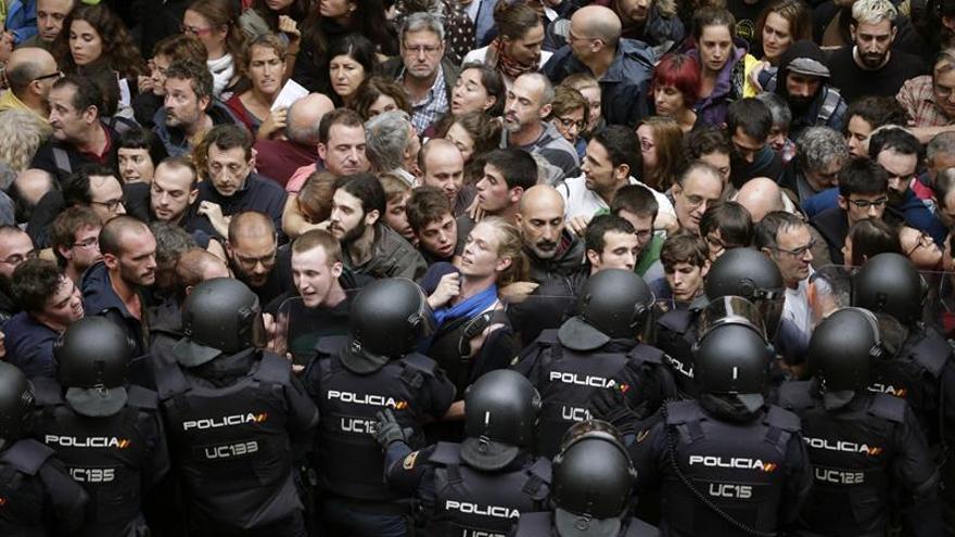 Agentes antidisturbios de la Policía Nacional forman un cordón de seguridad en los alrededores de un colegio en Barcelona