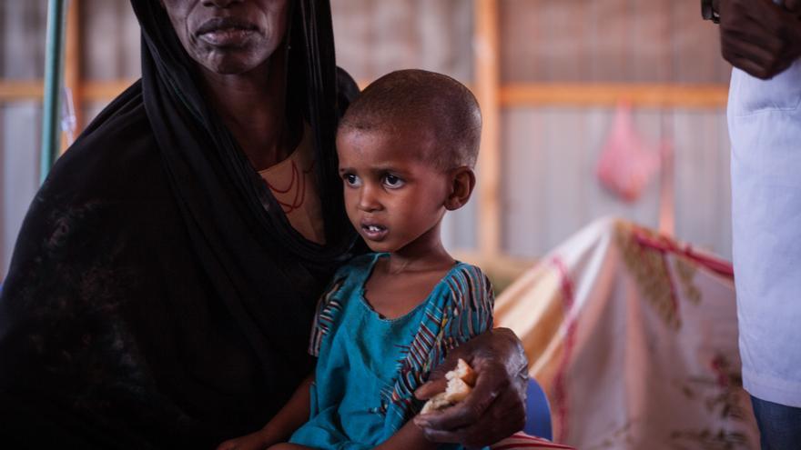 Asha (nombre ficticio), de 4 años, con su abuela Sulekha en el centro de tratamiento del cólera del hospital Bayhaw en Baidoa (Somalia). Sulekha está cuidando a su nieto mientras su hija está con los otros niños en un campamento fuera de Baidoa. 