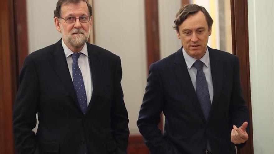  El presidente del Gobierno, Mariano Rajoy (i), junto al portavoz parlamentario del PP, Rafael Hernando (d), en los pasillos del Congreso de los Diputados 