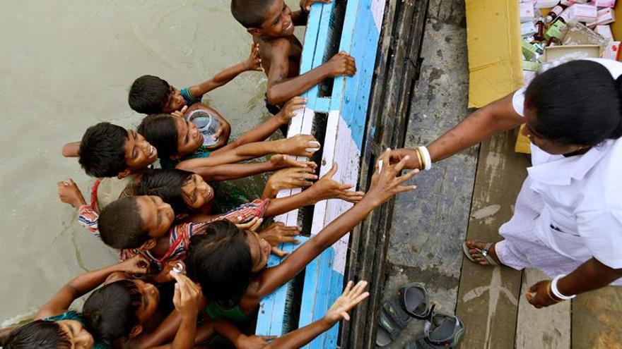 Niños afectados por las inundaciones recogen medicinas de un barco del Centro de Salud Público de Jhargaon en el distrito de Morigaon, en Assam (India).