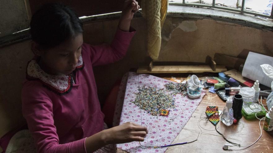 Las niñas y las mujeres son las encargadas de fabricar las artesanías que luego venderán en la calle, el principal sustento para la familia