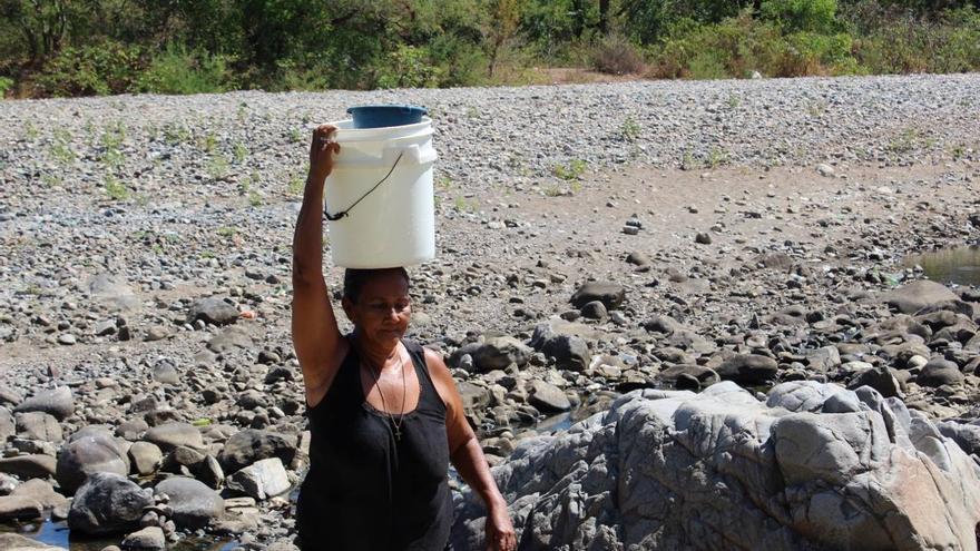 Una mujer transporta agua en su cabeza en una de las comunidades nicaragüenses.