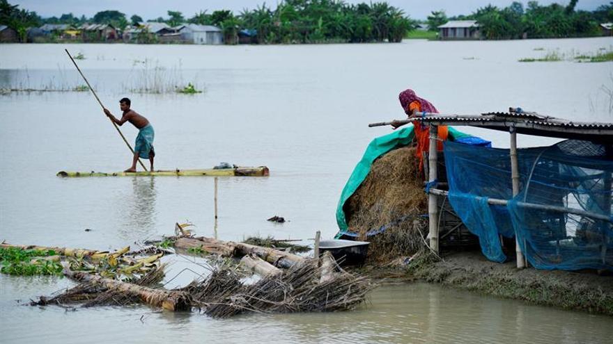 Una pareja busca sus pertenencias tras las inundaciones en el distrito de Morigaon, en Assam (India).