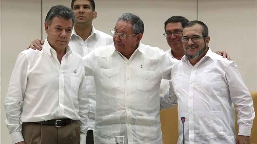 Raúl Castro, en el centro, abraza al presidente Santos y al comandante general de las FARC, Timoteo Jiménez./ EFE 
