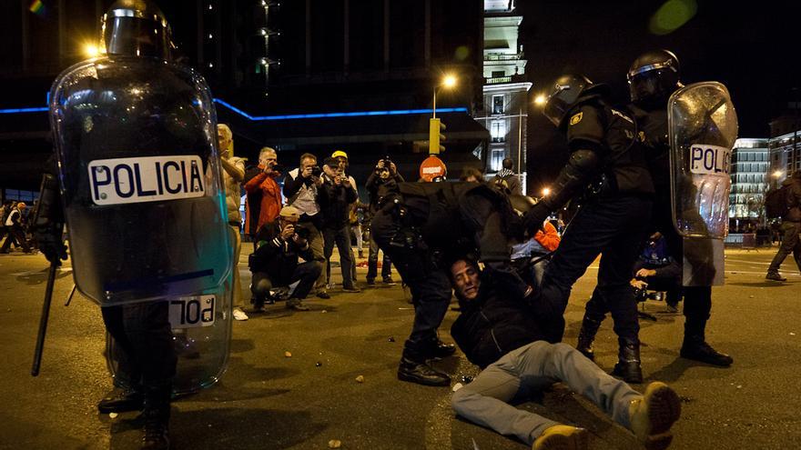La policía arrasta por el suelo a uno de los detenidos tras los disturbios de anoche en Madrid. /Javi Julio