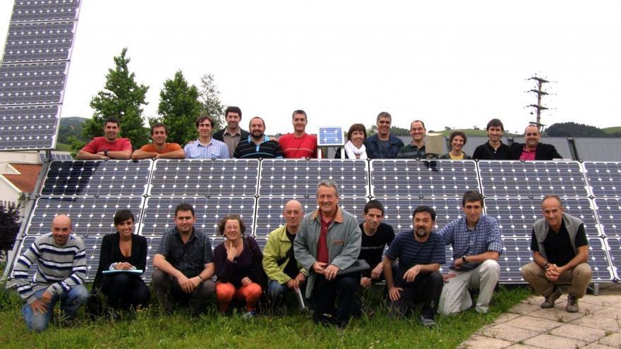 Miembros de la cooperativa posan junto a placas de energía fotovoltaica. 