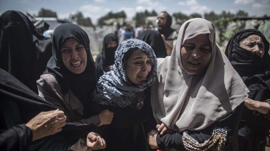 Mujeres palestinas de Gaza lloran por la muerte de varios integrantes de una familia, entre ellos niños (Efe)