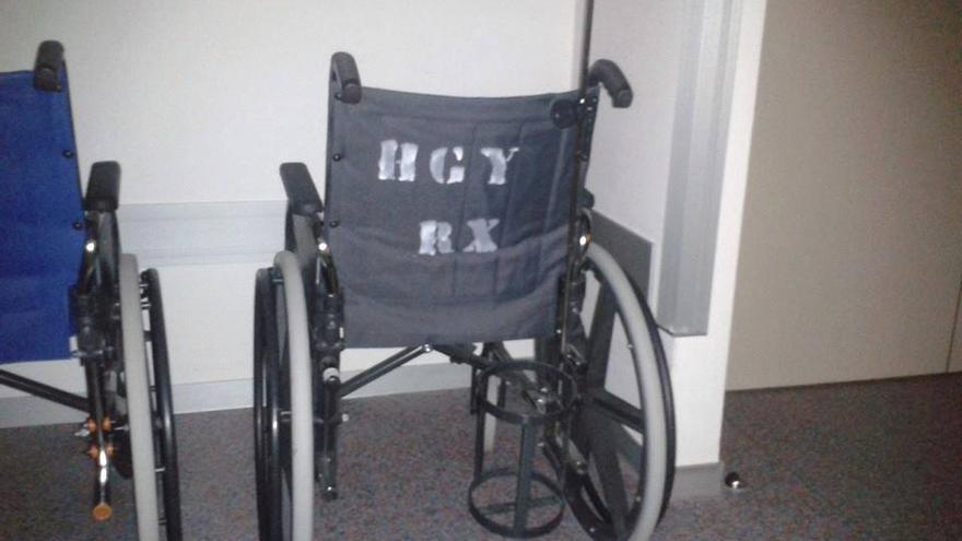 Una silla de ruedas del nuevo hospital privado, identificada con las siglas del anterior hospital público, el General Yague.