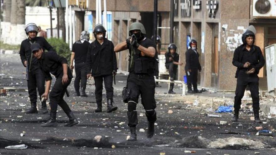  Un policía egipcio se dispone a disparar un bote de gases lacrimógenos contra unos manifestantes (EFE archivo)