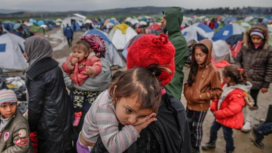 Un grupo de refugiados espera para cruzar la frontera entre Grecia y Macedonia en un campamento de refugiados cerca de Idomeni (Grecia), 9 de marzo de 2016.
