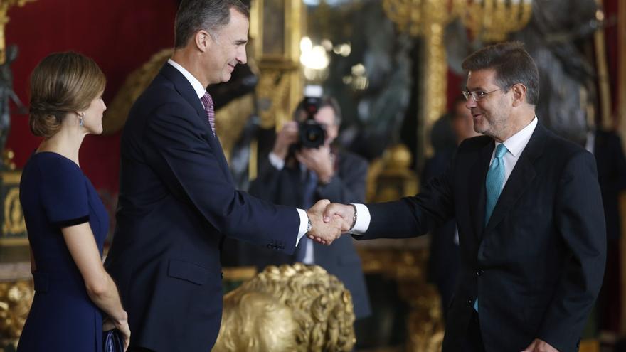 MADRID, 12/10/2015.- Los Reyes Felipe y Letizia saludan al ministro de Justicia, Rafael Catalá (d), al comienzo de la recepción que han ofrecido hoy en el Palacio Real a los representantes de las principales instituciones.