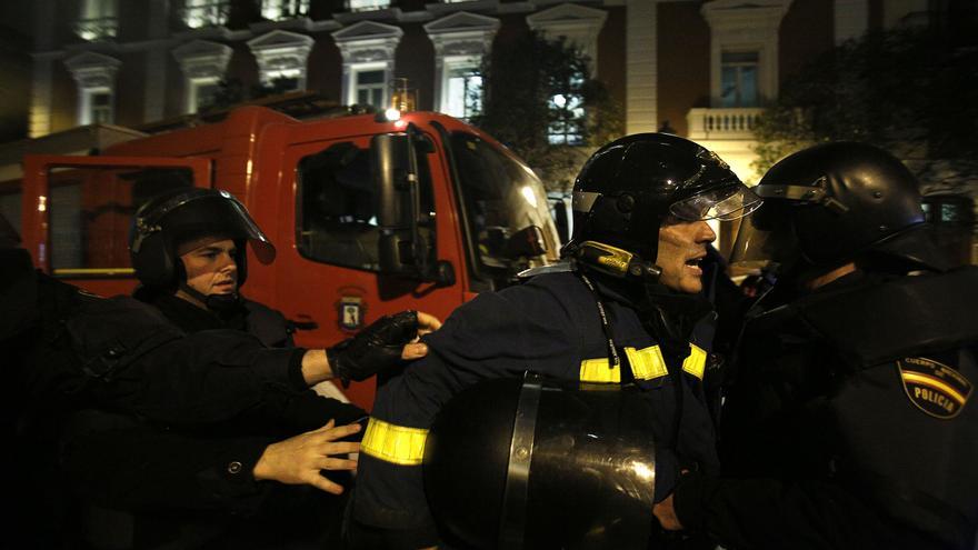 Los agentes conducen al bombero a un vehículo policial / Olmo Calvo