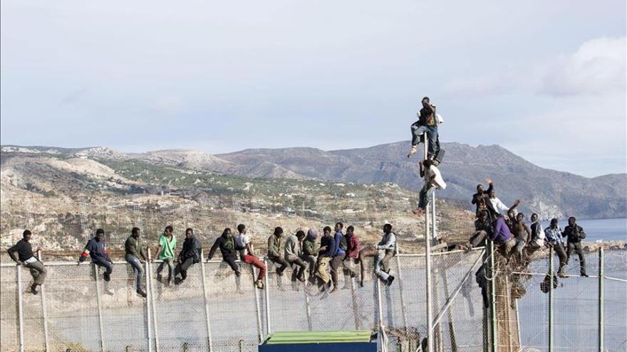 Unos 25 subsaharianos llevan varias horas encaramados en la valla de Melilla