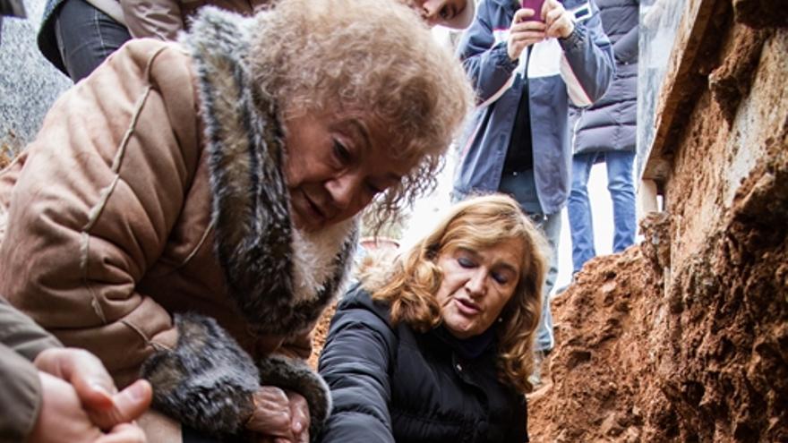 Milagros y su hija Pilar contemplan los restos mortales de Vicenta en la fosa anónima donde fue enterrada sobre su hijo Jesús / ARMH