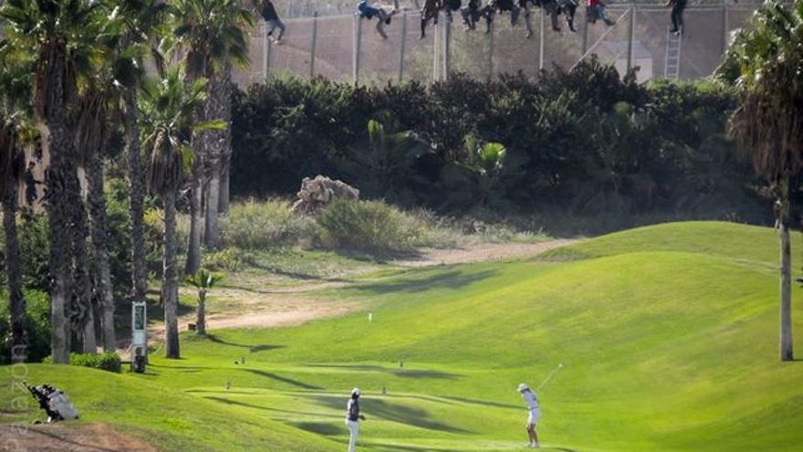 Valla de Melilla con doce personas doce inmigrantes frente a campo de golf. Fotografa Jos Palazn-Pr