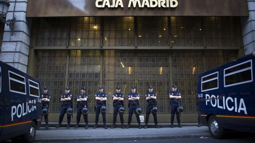 Policías vigilan una sede de Caja Madrid, en mayo de 2012.