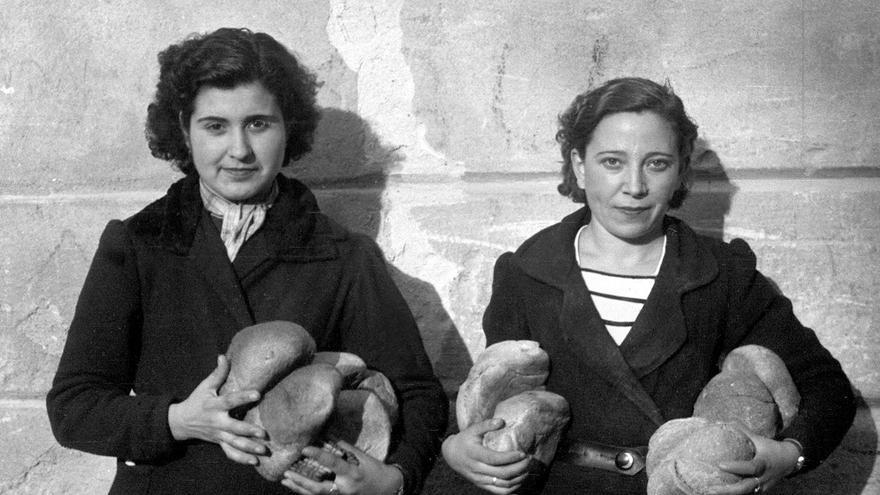 Dos muchachas transportan a sus hogares varias hogazas de pan repartidas por un camión de Auxilio Social. Enero de 1939 /EFE