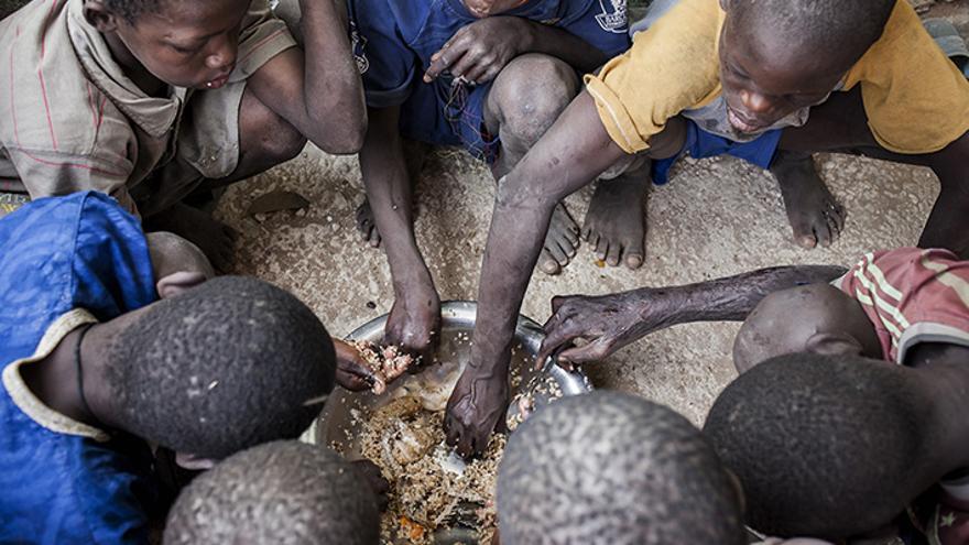 Varios niños talibés comiendo en una daara de M'bour, Senegal. Varias ONG denuncian escasez de alimentos para los menores y maltrato por parte de sus explotadores. | Lucas Vallecillos. 