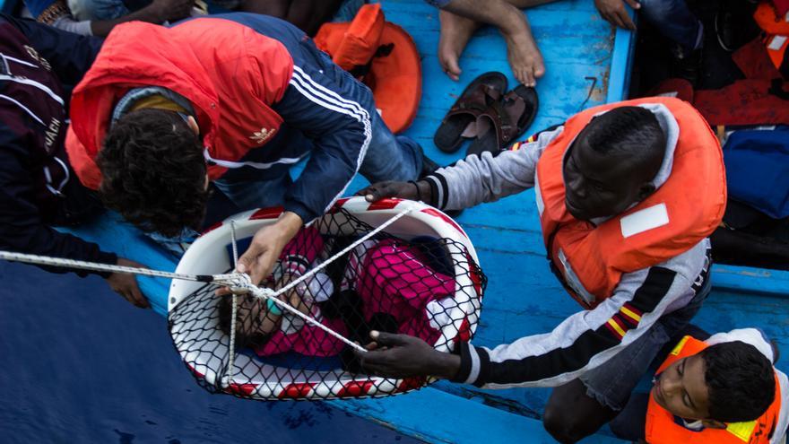 Los equipos de rescate del Bourbon Argos elevan a un bebé desde la cubierta de una precaria embarcación de madera. Según ACNUR, a finales de 2015, la mitad de los refugiados en todo el mundo eran niños. Fotografía: Borja Ruiz Rodriguez/MSF.