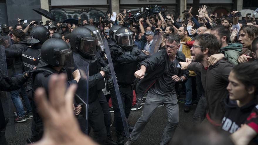 Descripción : People confronts Spanish riot police near a voting site at a school assigned to be a polling station by the Catalan government in Barcelona, Spain, Sunday, 1 Oct. 2017. Spanish riot police have forcefully removed a few hundred would-be voters from several polling stations in Barcelona.