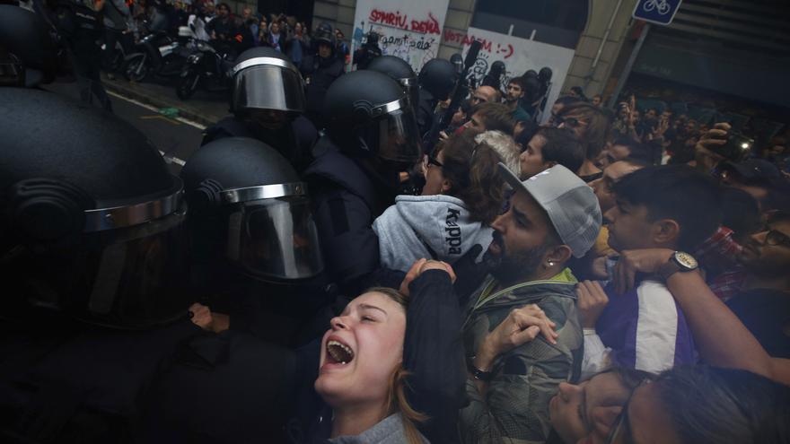 A girls grimaces as Spanish National Police pushes away Pro-referendum supporters outside the Ramon Llull school assigned to be a polling station by the Catalan government in Barcelona, Spain, early Sunday, 1 Oct. 2017. Catalan pro-referendum supporters vowed to ignore a police ultimatum to leave the schools they are occupying to use in a vote seeking independence from Spain. 