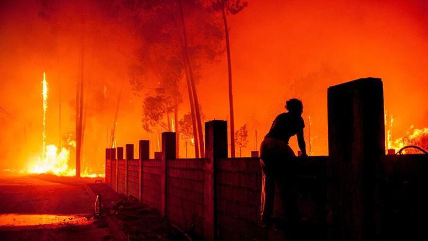 Una mujer lucha contra las llamas en un incendio forestal declarado en Vieira de Leiria en Marinha Grande (Portugal) este lunes, 16 de octubre. 