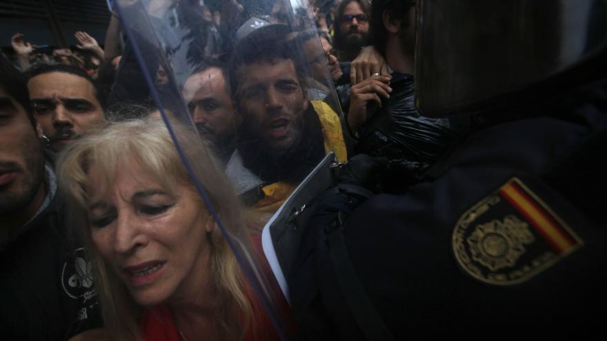 Pro-referendum supporters clash with Spanish National Police outside the Ramon Llull school assigned to be a polling station by the Catalan government in Barcelona, Spain, early Sunday, 1 Oct. 2017. Catalan pro-referendum supporters vowed to ignore a police ultimatum to leave the schools they are occupying to use in a vote seeking independence from Spain. 
