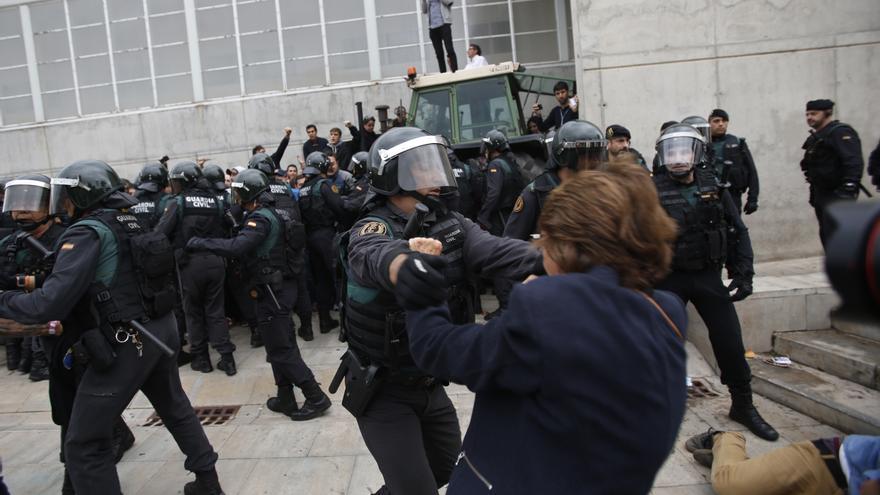 Civil guards clear people away from the entrance of a sports center, assigned to be a polling station by the Catalan government in Sant Julia de Ramis, near Girona, Spain, Sunday, Oct. 1, 2017. Scuffles have erupted as voters protested as dozens of anti-rioting police broke into a polling station where the regional leader was expected to show up for voting on Sunday. 