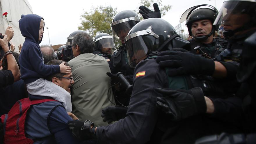 Civil guards clear people away from the entrance of a sports center, assigned to be a polling station by the Catalan government and where Catalan President Carles Puigdemont is expected to vote, in Sant Julia de Ramis, near Girona, Spain, Sunday, Oct. 1, 2017. Catalan pro-referendum supporters vowed to ignore a police ultimatum to leave the schools they are occupying to use in a vote seeking independence from Spain. 