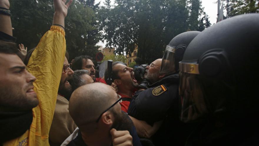 Spanish national police scuffle with people trying to reach a voting site at a school assigned to be a polling station by the Catalan government in Barcelona, Spain, Sunday, 1 Oct. 2017. Catalan pro-referendum supporters vowed Saturday to ignore a police ultimatum to leave the schools they are occupying to use in a vote seeking independence from Spain. 